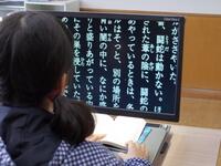 拡大読書器を使用し、教科書を読んでいる画像