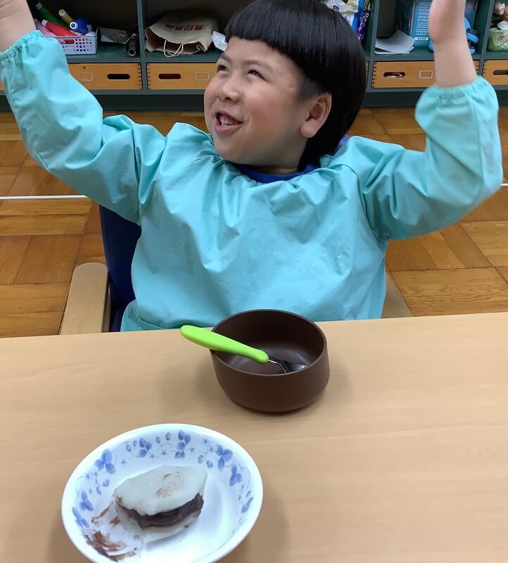 幼児がかしわもちを食べて喜んでいます。