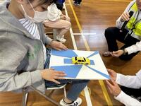 児童が自動車の死角を表現した立体模型を触図している画像