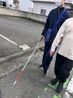 高等部生徒が白杖を突きながら歩いている画像
