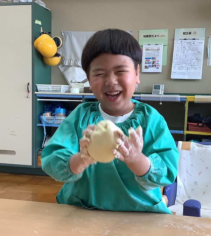 幼児が生地をこねています