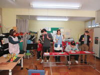 ハンドベル、ヴァイオリンの演奏を近寄って聴く幼児