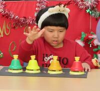 卓上ベルで演奏する幼児