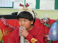 スタンドマイクを使って歌う幼児