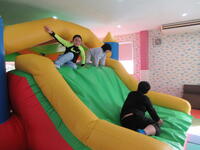 ふわふわ滑り台で遊ぶ児童