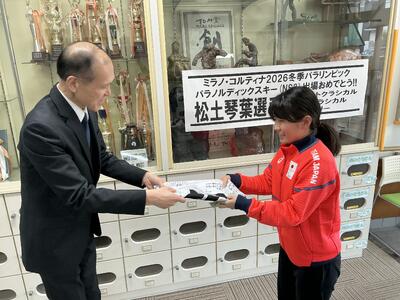 校長先生が日の丸を松土さんに渡している様子