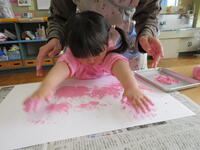 画用紙に手形を押す女児