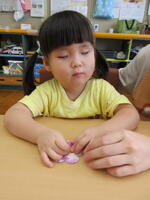 花型の画用紙にシールを貼る女児