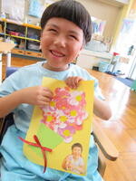 完成した作品を笑顔で見せる男児