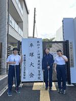 生徒が卓球大会の看板の前に立って記念撮影
